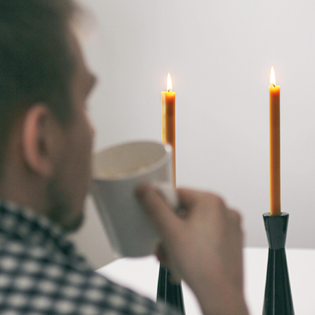 Man drinks hot beverage in the candle light