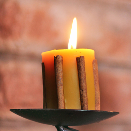 Beeswax pillar candles with cinnamon stick ornaments